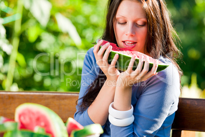 Eating fresh melon beautiful young woman bench