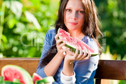 Eating fresh melon beautiful young woman bench