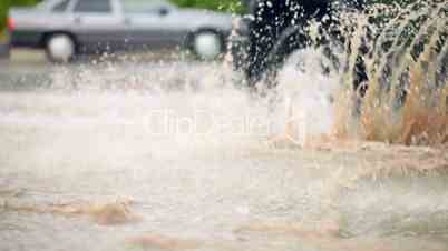 car splashes through a large puddle