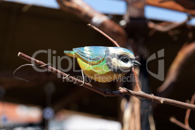 ceramic bird on a branch at the fair