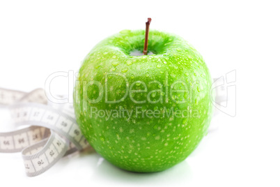 apple with water drops and measure tape isolated on white