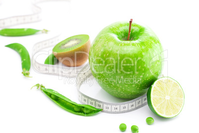 apple,lime,peas,kiwi and measure tape isolated on white