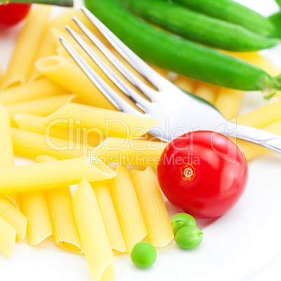 tomatoes, peas, pasta and fork on a plate isolated on white