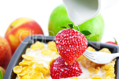 strawberry, peach, apple, kiwi, fork, milk and flakes in a bowl