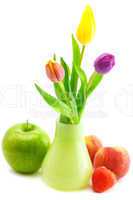 colorful tulips in vase,strawberries,apple and peach isolated on