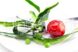 tomato,fork ,cucumber skin,peas and measure tape on a plate isol