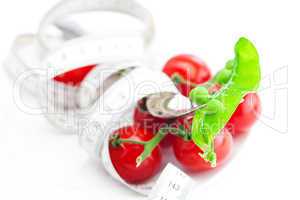 tomato,fork ,peas and measure tape on a plate isolated on white