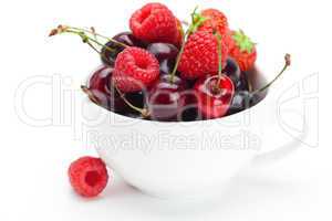 raspberries, strawberries and cherries in a bowl isolated on whi