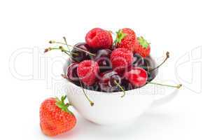 raspberries, strawberries and cherries in a bowl isolated on whi