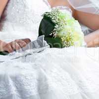 bouquet in the hands of the bride against the background of dres