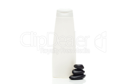 cosmetic containers and spa black stones isolated on white