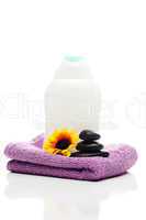 cosmetic containers,flower, towel and  black spa stones isolated
