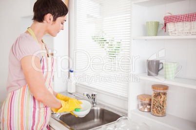 Beautiful brunette woman washing the dishes
