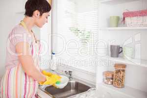 Beautiful brunette woman washing the dishes