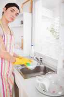 Sad woman washing the dishes