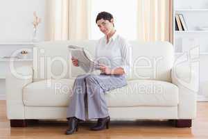 Gorgeous brunette businesswoman reading the news