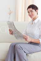 Portrait of a woman reading the news looking into the camera