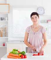 Smiling woman cutting vegetables