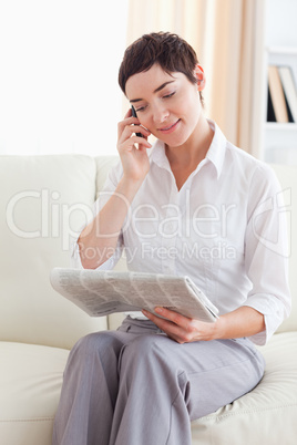 Woman with a cellphone and a newspaper