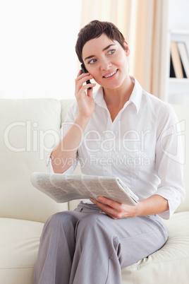 Brunette Woman with a cellphone and a newspaper