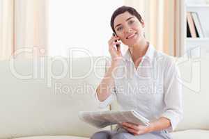 Smiling Woman with a cellphone and a newspaper