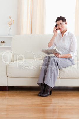 Brunette woman with a phone and a newspaper