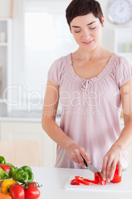 Cute woman slicing vegetables