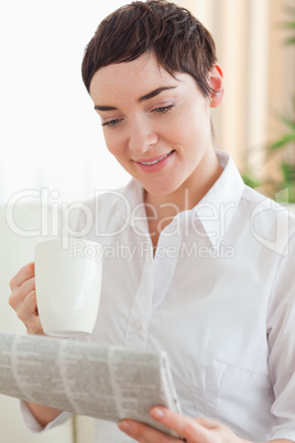 Cute woman with a cup and a newspaper