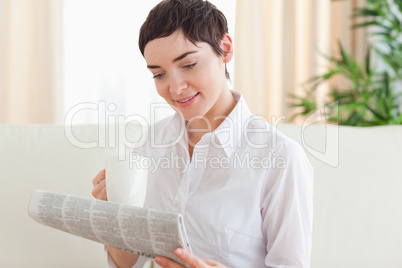 Brunette woman with a cup and a newspaper