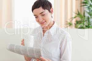 Brunette woman with a cup and a newspaper