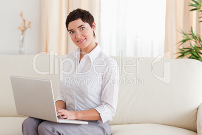 Woman sitting on a sofa with a laptop