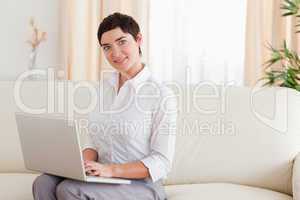 Woman sitting on a sofa with a laptop