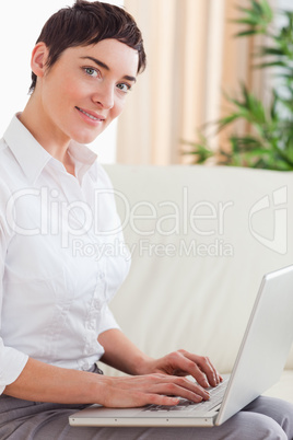 Brunette woman with a laptop looking into the camera