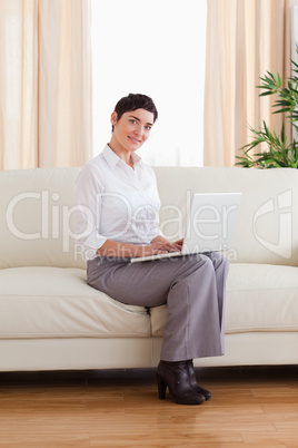 Short-haired woman with a laptop looking into the camera