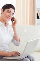 Short-haired woman with a laptop and a phone