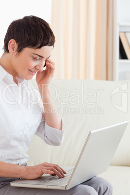 Charming Short-haired woman with a laptop and a phone