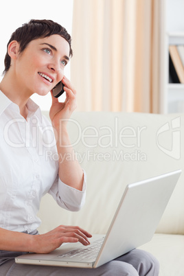 Charming woman with a laptop and a phone