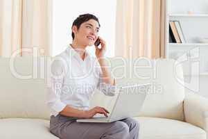 Gorgeous woman with a laptop and a phone