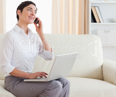 Gorgeous short-haired woman with a laptop and a phone