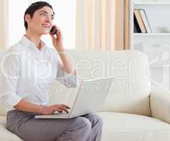 Gorgeous short-haired woman with a laptop and a phone