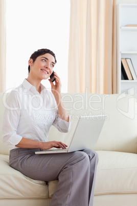 Woman with a laptop and a phone looking into the camera