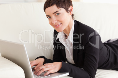 Businesswoman lying on a sofa with a laptop