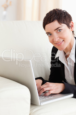 Close up of a brunette Businesswoman lying on a sofa with a lapt