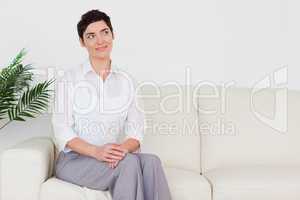 Beautiful brunette woman sitting on a sofa