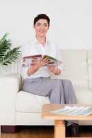 Smiling woman reading a magazine