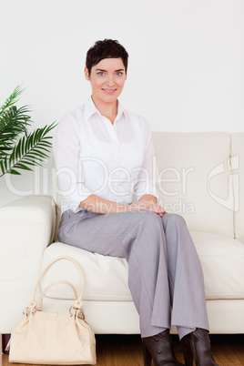 Charming short-haired woman sitting on a sofa