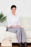 Charming short-haired woman sitting on a sofa