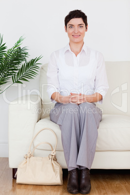 Smiling short-haired woman sitting on a sofa