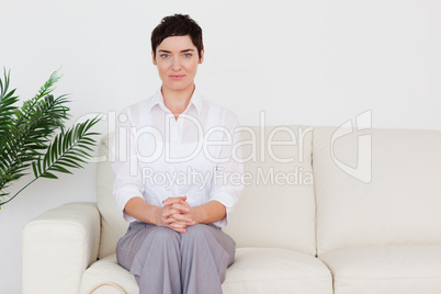 Brunette woman sitting on a sofa