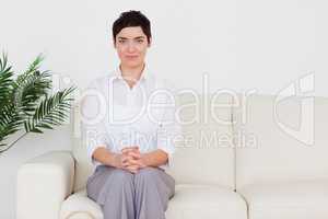Brunette woman sitting on a sofa